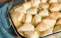 Chicken pot pie with biscuits served on a rustic wooden table