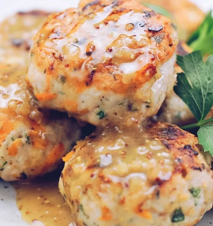 Homemade chicken rissoles served on a plate with fresh herbs