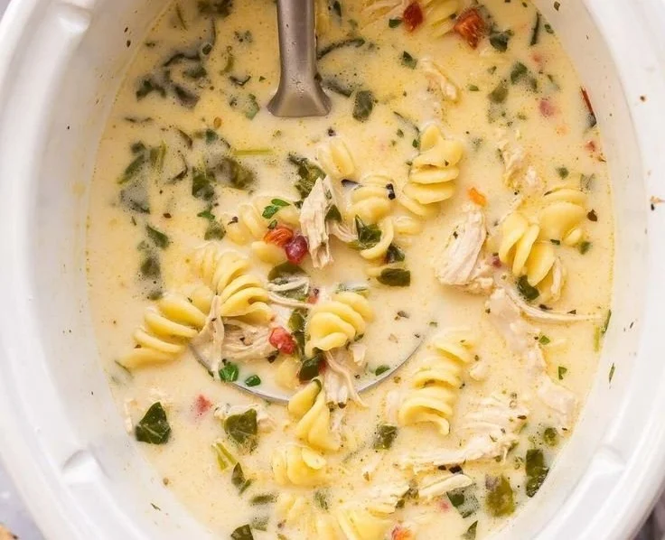 Creamy Italian slow cooker chicken noodle soup in a bowl with herbs and noodles.