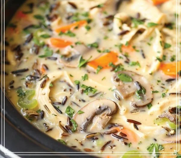 Bowl of Crockpot Chicken Wild Rice Soup garnished with herbs