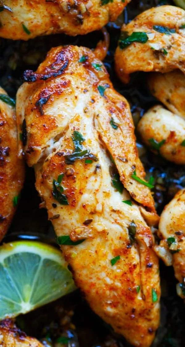 Delicious Garlic Butter Chicken Tenders garnished with herbs on a plate
