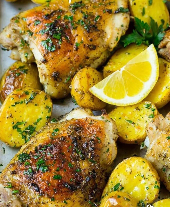 Greek chicken and potatoes dish garnished with herbs