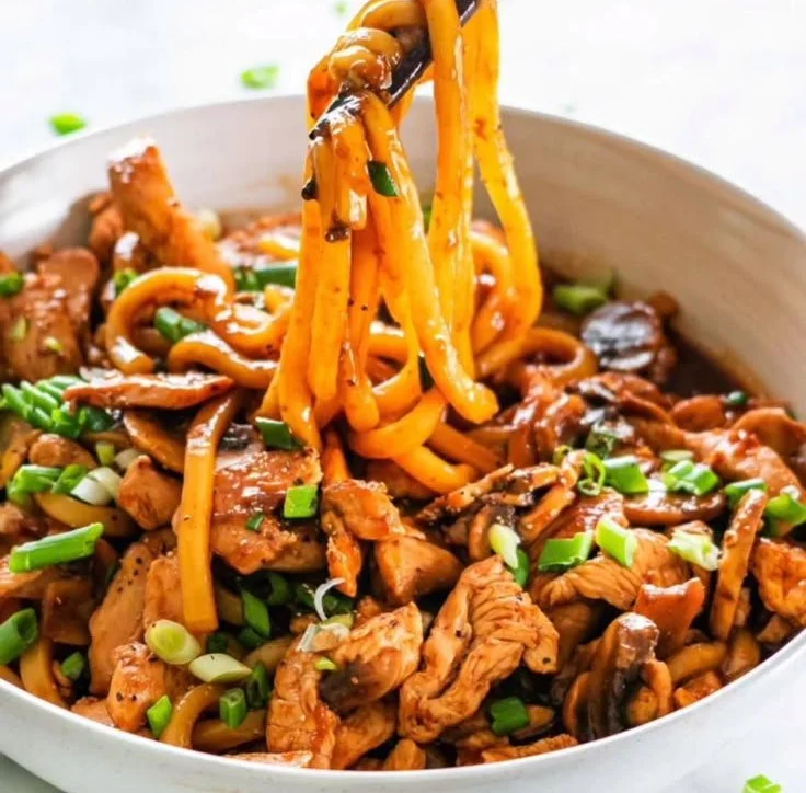 Bowl of Hoisin Chicken Udon noodles garnished with vegetables