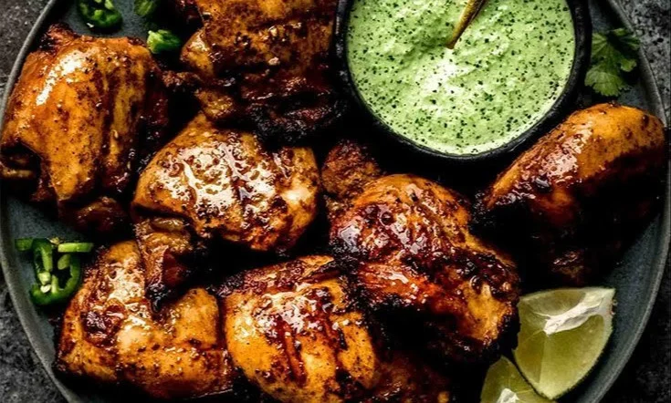 Peruvian chicken served with creamy green sauce on a plate