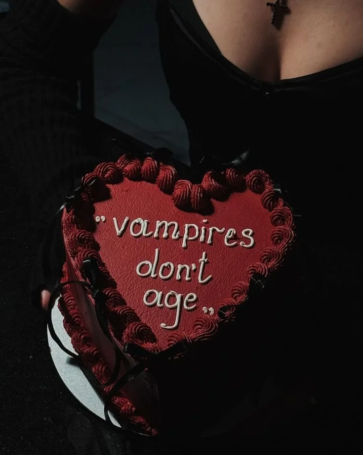 Spooky vampire birthday cake with red frosting and edible decorations