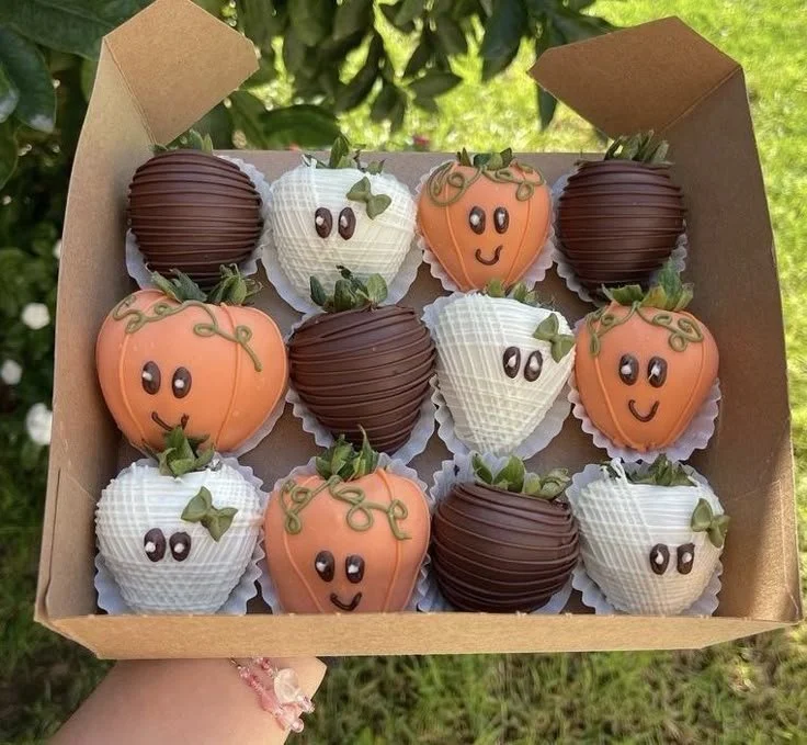 Fall-themed chocolate covered strawberries and pumpkins for Halloween