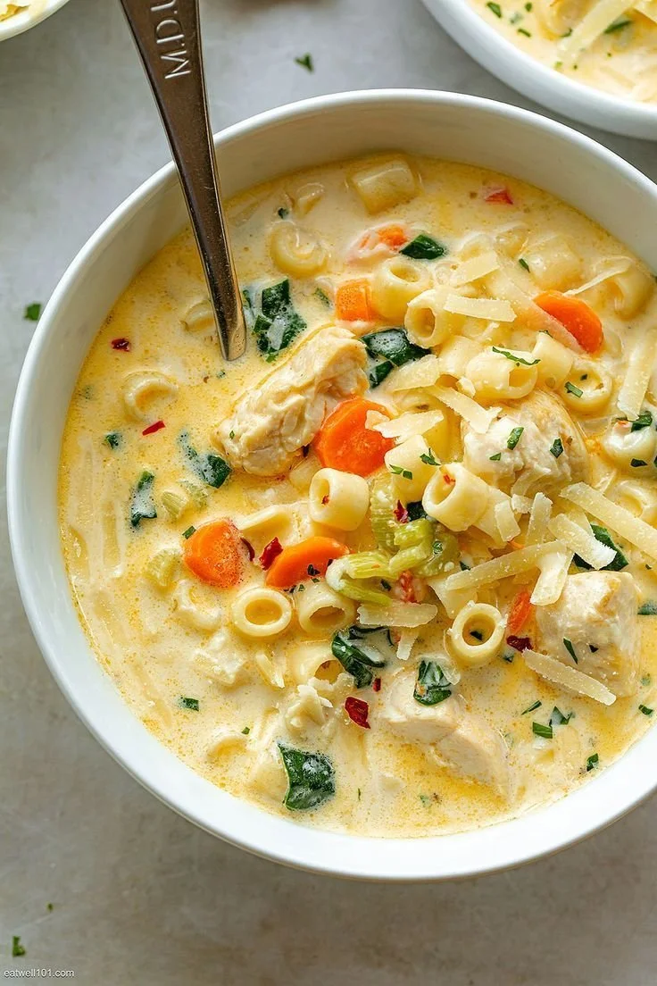 Creamy chicken soup with pasta and spinach in a bowl