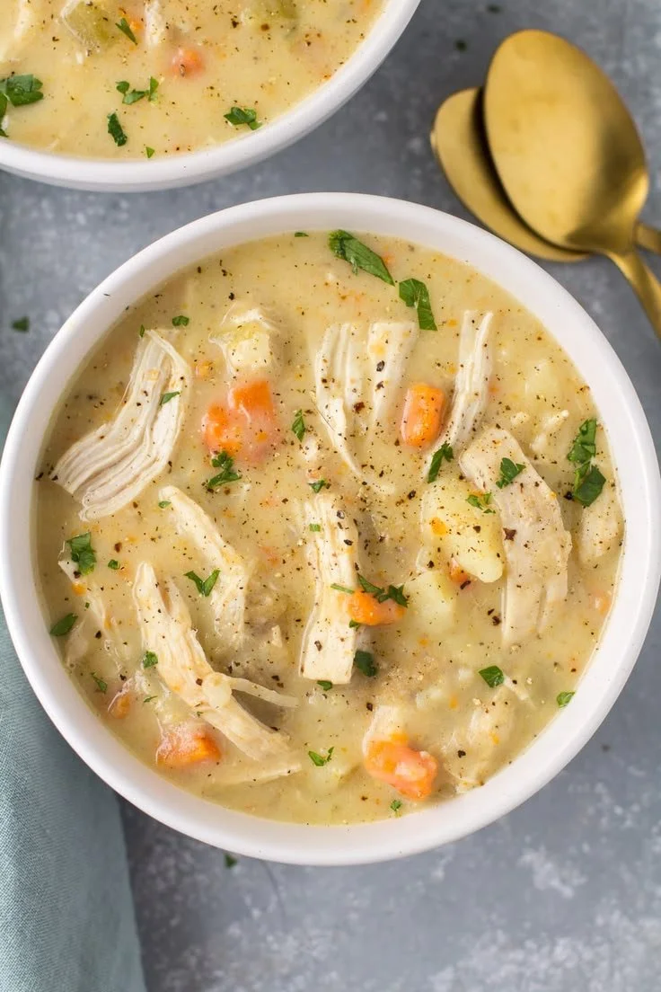 Healthy Chicken Pot Pie Soup served in a bowl with fresh herbs on top.